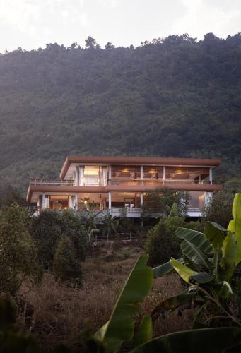 a house on top of a hill with trees at Amaya Kampot Homestays in Kampot