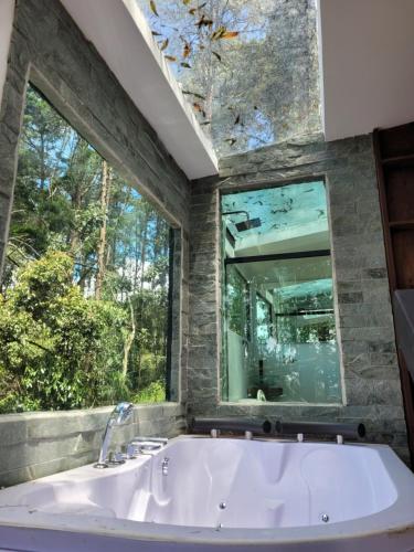 baño grande con ventana grande y bañera en Cabaña Aventurina- La pascana Ecolodge Entorno natural excepcional, conexión con la naturaleza y avistamiento de aves, Ubicado a 3km del metrocable y Parque Arvi, Guarne, en Mazo