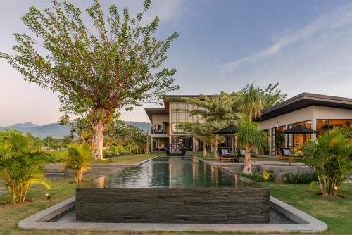 a resort with a pond in front of a building at Sea View Pool Villa - Exclusive Beachfront Property in Buleleng