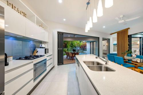 a kitchen with a sink and a counter top at Belle Escapes Luxury Beach Edge in Palm Cove