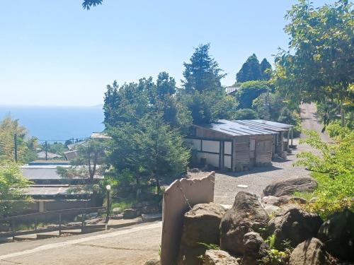 a building on the side of a hill with rocks at 伊豆Cocoグランピングリゾート in Ito