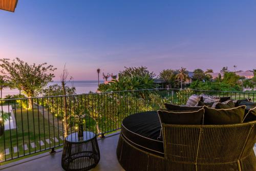 a balcony with a table and chairs and the ocean at Sea View Pool Villa - Exclusive Beachfront Property in Buleleng