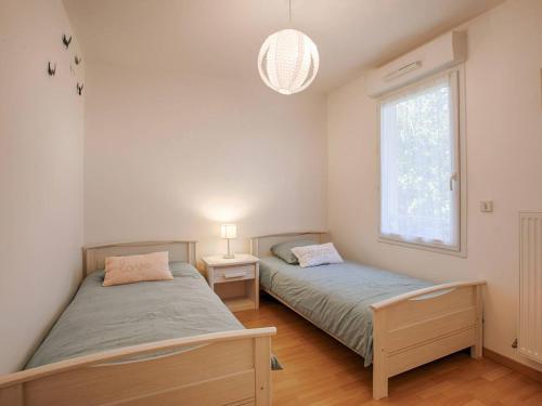 une chambre avec deux lits et une fenêtre dans l'établissement Appartement spacieux 70m², piscine, parking, près plage et commerces - FR-1-788-38, à Merville-Franceville-Plage