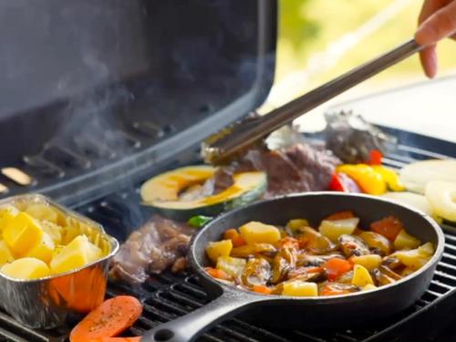 a pan of food on a grill with meat and vegetables at 伊豆Cocoグランピングリゾート in Ito