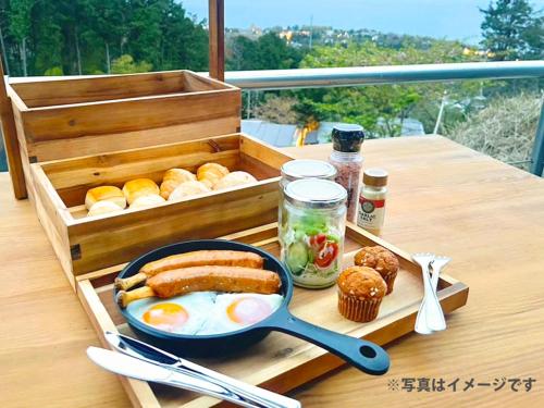 a breakfast tray with eggs and bread on a table at 伊豆Cocoグランピングリゾート in Ito
