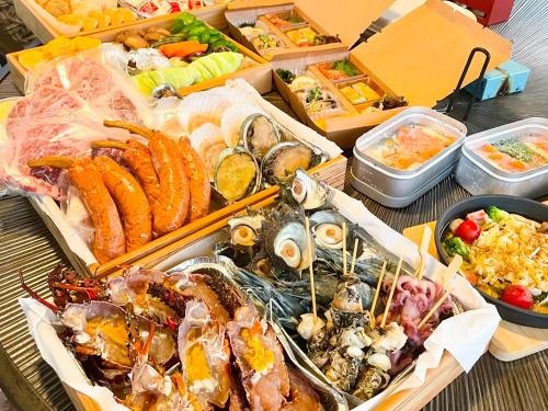 a table filled with different types of seafood and vegetables at 伊豆Cocoグランピングリゾート in Ito