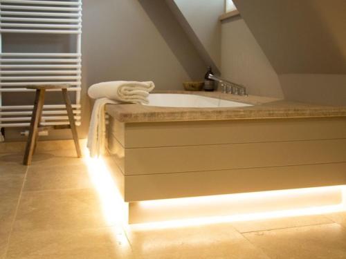 a bathroom with a bath tub with a light in it at Oceans 18 Comfortable holiday residence in Wenningstedt