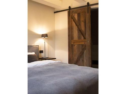 a bedroom with a sliding barn door next to a bed at Oceans 18 Comfortable holiday residence in Wenningstedt