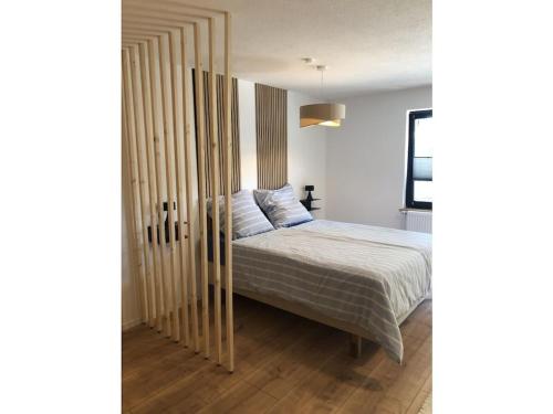 Un dormitorio con una cama con una partición de madera. en DomiLia Comfortable holiday residence, en Owingen