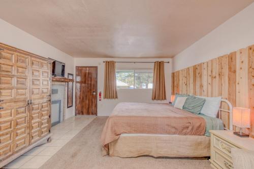 a bedroom with a large bed and a kitchen at Enchanted Hideaway Cabins and Cottages in Ruidoso