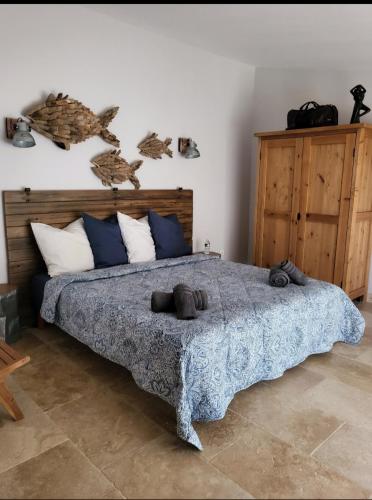 une chambre avec un grand lit avec une couverture bleue dans l'établissement hammam et jacuzzi en Provence, à Caphan