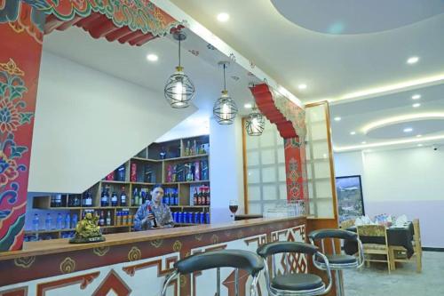 a restaurant with a bar with chairs and books at The BD Hotel in Thimphu