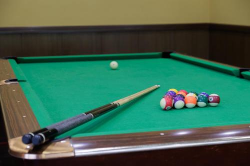 a pool cue and balls on a pool table at Tazawako Lake Resort & Onsen in Senboku