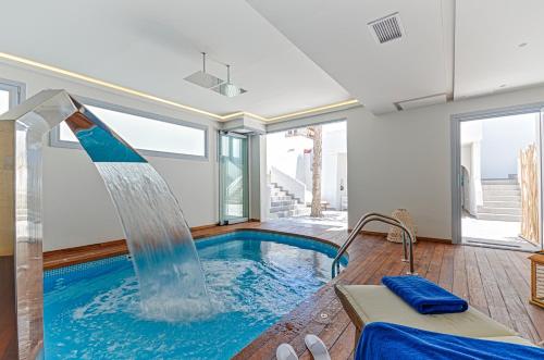 a swimming pool with a water slide in a house at Hotel Grotta in Naxos Chora