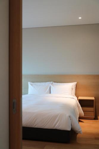 a bedroom with a large bed with white sheets at Haenam 126 Hotel in Haenam