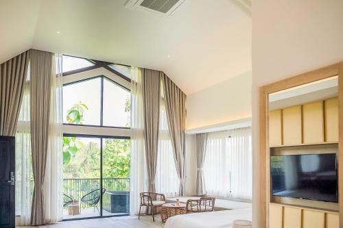 a bedroom with a bed and a large window at Villa De Leaf River Kaeng Krachan in Phetchaburi