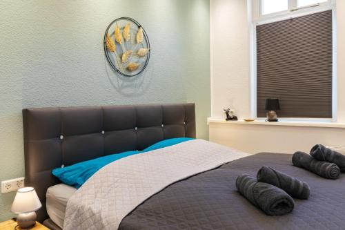 a bed in a bedroom with a clock on the wall at Richter Altstadtappartements in Goslar