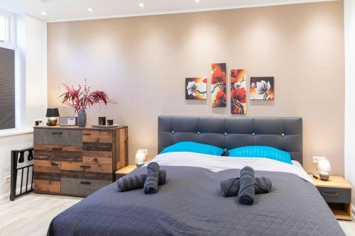 a bedroom with a bed with blue pillows at Richter Altstadtappartements in Goslar