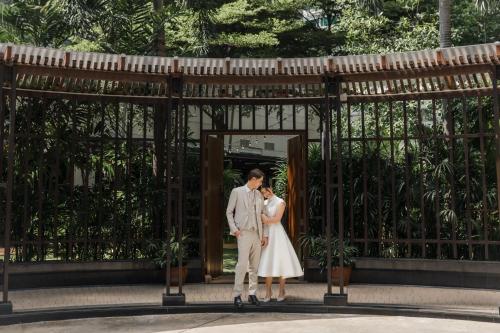 a bride and groom standing in front of a gate at Marriott Executive Apartments Sukhumvit Park, Bangkok in Bangkok