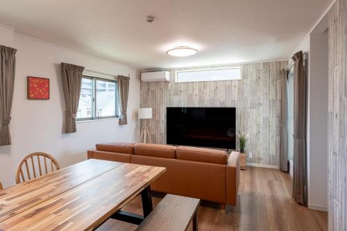 a living room with a couch and a table at Ici Japon Village in Tokyo