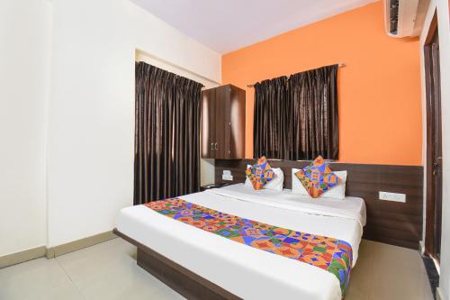 a bedroom with two beds with orange walls at FabExpress Comfort Executive - Nr Butterfly Park - Hinjawadi in Pune