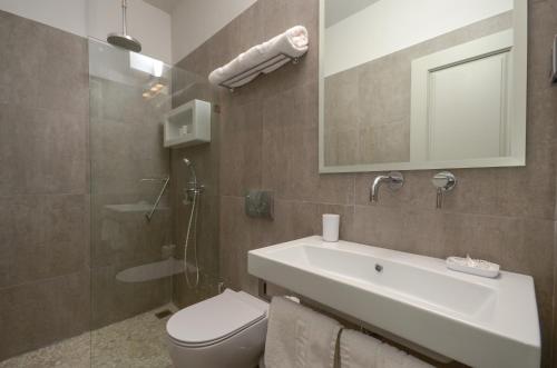 a bathroom with a sink and a toilet and a mirror at Hotel Grotta in Naxos Chora