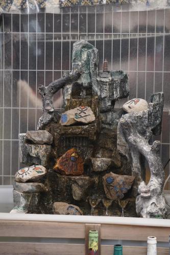 a stone fountain in front of a wall at Jayden NAXI Healing Lodge臣安纳西疗愈小院 - Namaste in Lijiang