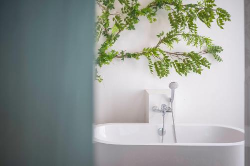 a white bath tub with a green plant above it at Villa De Leaf River Kaeng Krachan in Phetchaburi