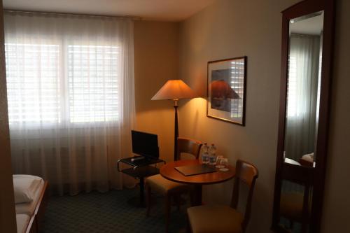 a hotel room with a table with a laptop on it at Hotel & Restaurant Reinacherhof in Reinach