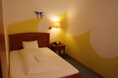 a bedroom with a bed and a table with a lamp at Hotel & Restaurant Reinacherhof in Reinach