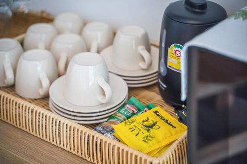 a tray filled with cups and plates next to a microwave at Villa De Leaf River Kaeng Krachan in Phetchaburi