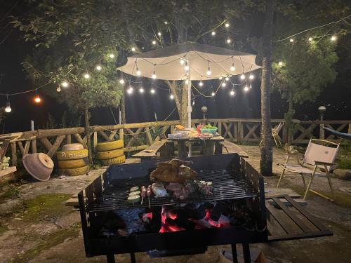 a grill in a yard with a tent with lights at Pea homestay in Sa Pa