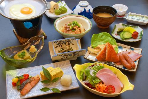 a table topped with plates of food and eggs at Hotel&Resort Yamanouchi Hills in Yamanouchi