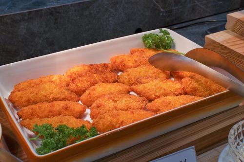 a tray of fried food with two wooden spoons at Hotel&Resort Yamanouchi Hills in Yamanouchi