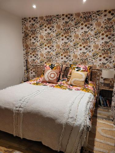 - une chambre avec un grand lit et du papier peint floral dans l'établissement Cosy wood Loc T2 