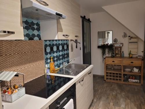 une cuisine avec un évier et un plan de travail dans l'établissement Cosy wood Loc T2 