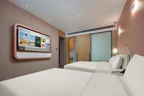 a hotel room with two beds and a flat screen tv at Atour Hotel Suzhou Wuzhong Taihu New Town in Suzhou