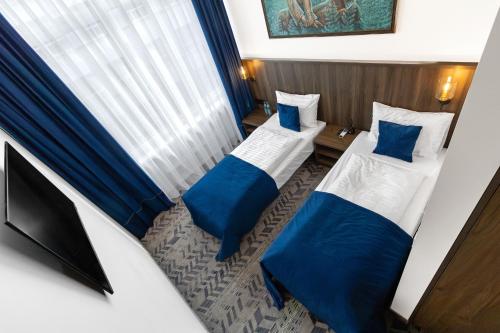 a room with two beds and a television in it at AN Hotel self check-in in Šiauliai