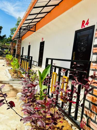 a fence in front of a building with flowers at David Hostel in Koh Rong