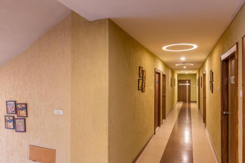 a hallway of a hospital with yellow walls at Vinayaga Inn by Poppys, Ooty in Ooty