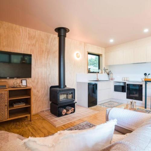 a living room with a wood stove in a kitchen at Just Down the Road in Branxholm