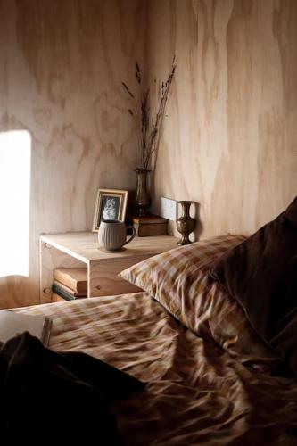 a bedroom with a bed and a table with a picture at Just Down the Road in Branxholm
