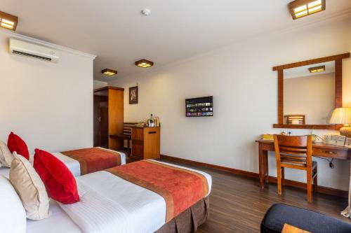 a hotel room with two beds and a desk at Atithi Resort & Spa in Pokhara