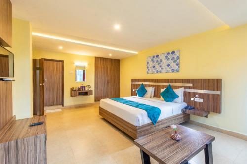 a bedroom with a large bed and a wooden table at Vinayaga Inn by Poppys, Ooty in Ooty