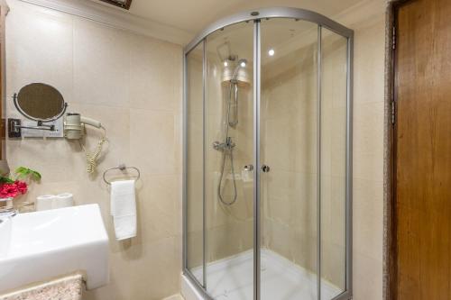 a shower in a bathroom with a glass shower stall at Atithi Resort & Spa in Pokhara