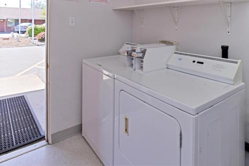 uma lavandaria branca com máquina de lavar e secar roupa em Majestic Inn & Suites em Klamath Falls