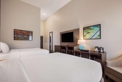 a hotel room with two beds and a flat screen tv at La Quinta Inn & Suites by Wyndham Sulphur Lake Charles in Sulphur