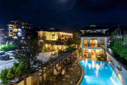a hotel with a swimming pool at night at Atithi Resort & Spa in Pokhara
