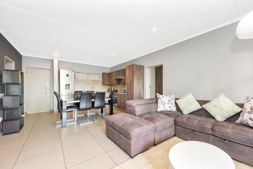 a living room with a couch and a table at The Odyssey Lifestyle Complex Morningside - 2 BR in Johannesburg