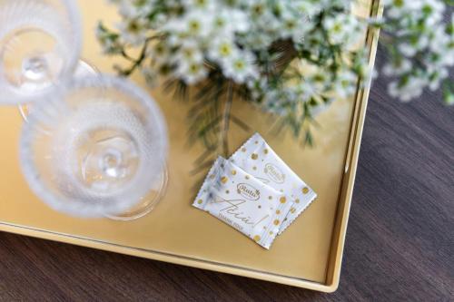 a brass tray with a vase with flowers and a coaster at AN Hotel self check-in in Šiauliai